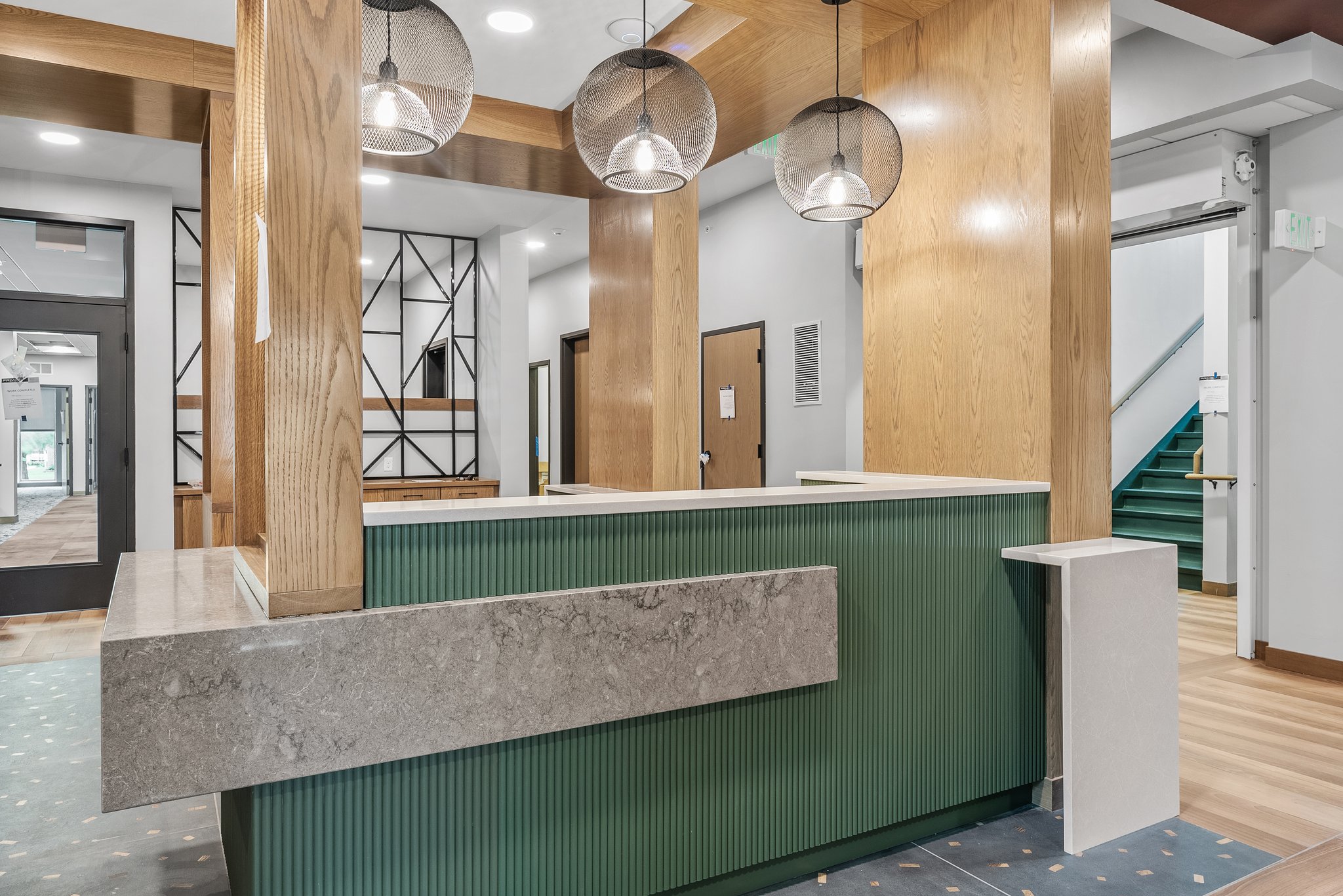 Modern custom reception desk in a commercial lobby with wood finish and contemporary design.