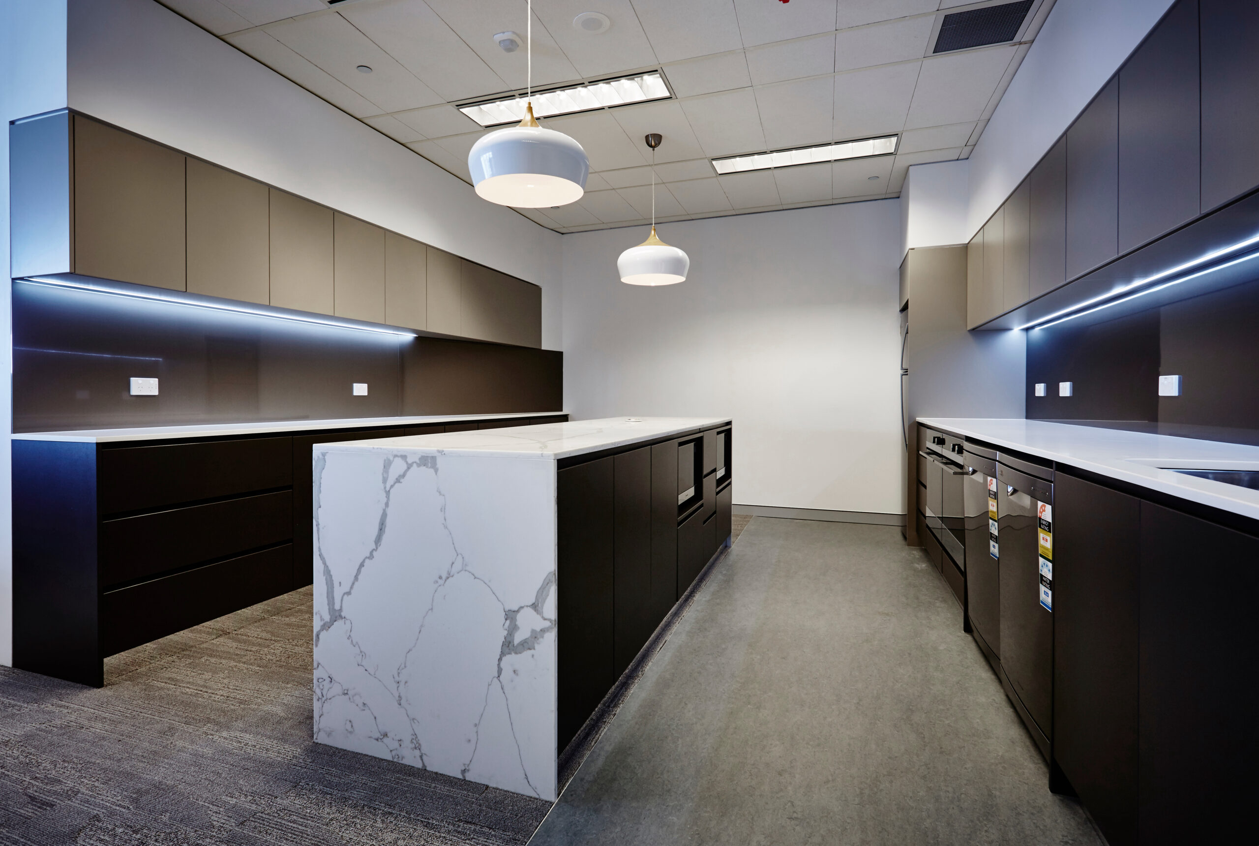 Commercial breakroom with custom solid surface countertops and modern cabinetry.