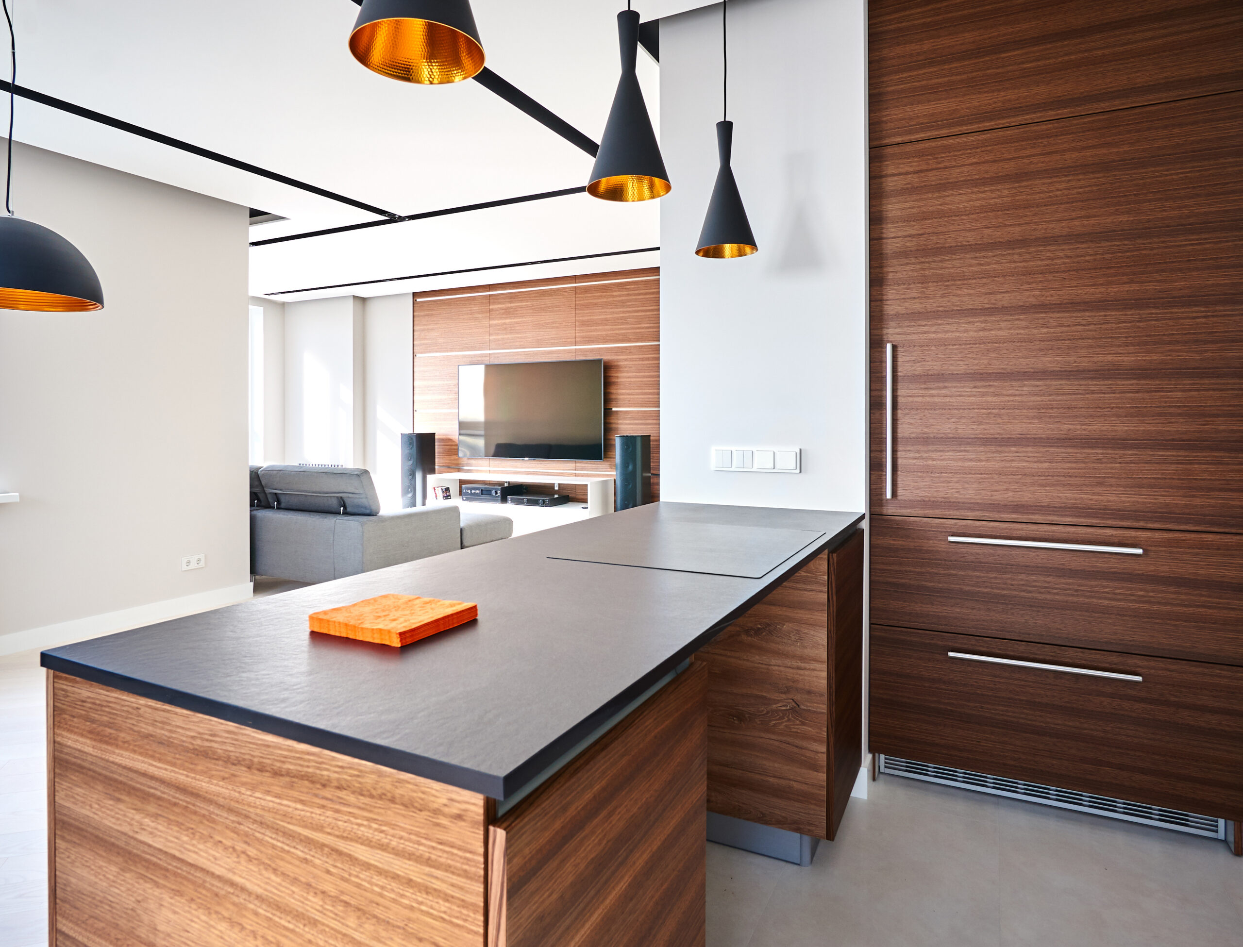 Modern kitchen with white drawers, black apron and countertop, island finished with walnut veneer